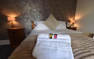 une chambre avec un lit avec des serviettes dessus dans l'établissement Whitburn House Hotel, à Preston