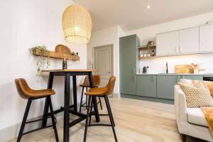 a kitchen and living room with a table and chairs at Apartment Ten Pelican House in Bournemouth