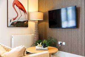 a living room with a table with a lamp and a tv at Apartment Ten Pelican House in Bournemouth +7 photos
