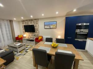 a living room with a table and a dining room at Villa Les Sables in Condette