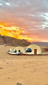 two domes in the desert with the sunset in the background at Rum Paradise luxury camp in Wadi Rum +103 photos