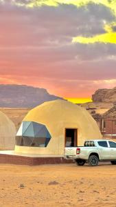 a truck parked in front of a tent in the desert at Rum Paradise luxury camp in Wadi Rum