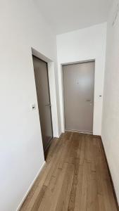 um quarto vazio com duas portas e um piso de madeira em Lea Apartement - Ruhiges Studio em Schaffhausen