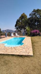 une piscine avec un chemin en pierre autour dans l'établissement Pousada Da Montanha, à Extrema