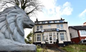 une statue de lion blanche devant un bâtiment dans l'établissement Whitburn House Hotel, à Preston