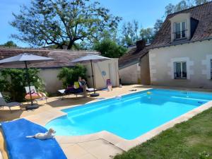 eine Frau, die auf einem Stuhl neben einem Swimmingpool sitzt in der Unterkunft L'Atout de France in Fléré-la-Rivière