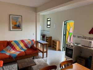 a living room with a couch and a kitchen at Casa Aquarius in Camanducaia