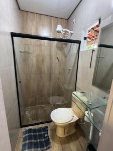 een badkamer met toilet en glazen douche bij CASA de Praia em Jóia do Atlântico in Ilhéus