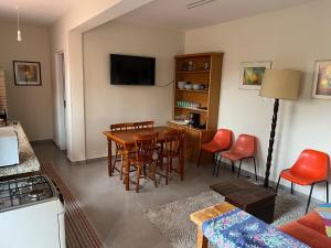 a living room with a table and chairs and a television at Casa Aquarius in Camanducaia