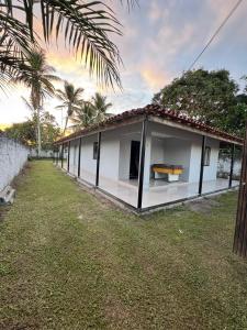 een klein wit gebouw met een grasveld bij CASA de Praia em Jóia do Atlântico in Ilhéus