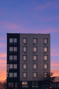 ein hohes Gebäude mit Fenstern bei Sonnenuntergang in der Unterkunft Bkway Hotel Brooklyn in Brooklyn