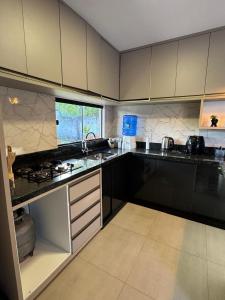 een keuken met witte kasten en een aanrechtblad bij CASA de Praia em Jóia do Atlântico in Ilhéus +12 foto's