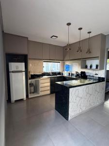 een keuken met een zwart-wit aanrecht bij CASA de Praia em Jóia do Atlântico in Ilhéus