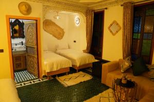 a bedroom with two beds and a mirror at Riad Dar El bellar in Fès +95 photos