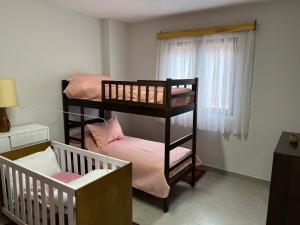a small room with two bunk beds and a window at Casa Aquarius in Camanducaia