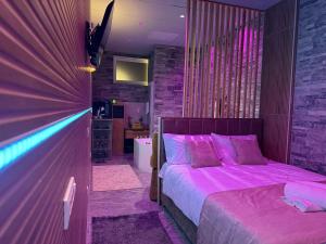 ein Schlafzimmer mit einem Bett mit violetter Bettwäsche in der Unterkunft Dubai Spa Apartments - Jacuzzi, Sauna & Free Parking in Veternik + 11 Fotos