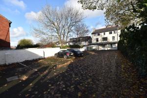 une voiture garée dans une allée à côté d'une maison dans l'établissement Whitburn House Hotel, à Preston
