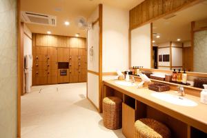 a bathroom with two sinks and a large mirror at Dormy Inn Nagano in Nagano