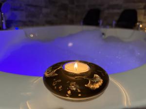 eine Kerze vor einer Badewanne in der Unterkunft Dubai Spa Apartments - Jacuzzi, Sauna & Free Parking in Veternik