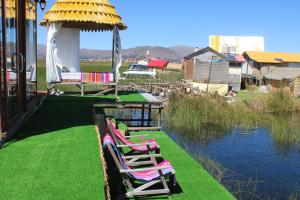 a group of chairs sitting on the grass by the water at Titicaca SUMA SARTIRI in Puno