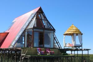 a frame house with a red roof and a gazebo at Titicaca SUMA SARTIRI in Puno