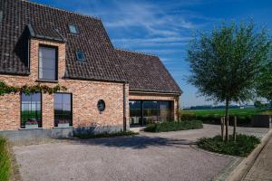 uma casa de tijolos com uma árvore na entrada em Vakantiewoning Amico em Gistel
