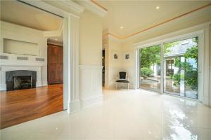 un salon vide avec une cheminée et une grande fenêtre dans l'établissement Tomies House, à Laune Bridge