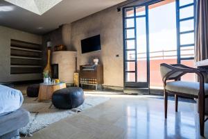 ein Zimmer mit einem Bett, einem Fernseher und einer Couch in der Unterkunft Fellah Hotel in Marrakesch