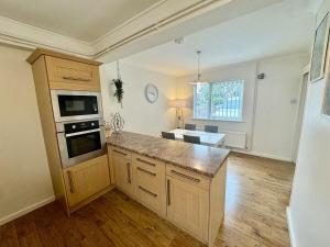 a kitchen with a large island in a room at Comfortable 3BR house-parking close to city centre in Kidlington
