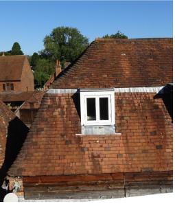une fenêtre sur le toit d'une maison en briques dans l'établissement Wolf Cottage Westerham, à Westerham