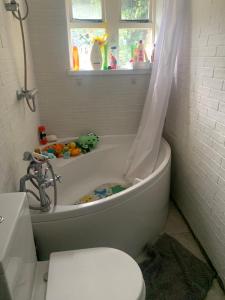 une salle de bain avec une baignoire, des toilettes et un lavabo dans l'établissement Wolf Cottage Westerham, à Westerham