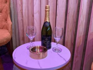 eine Flasche Champagner und zwei Weingläser auf dem Tisch in der Unterkunft Dubai Spa Apartments - Jacuzzi, Sauna & Free Parking in Veternik