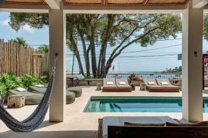 a patio with a hammock and a swimming pool at Barracuda Boutique in Itacaré