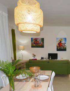 a living room with a green couch and a chandelier at Infiniti Instyle in Sosúa
