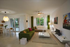 a living room with a green couch and a tv at Infiniti Instyle in Sosúa