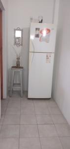 a white refrigerator in a room with a small table at Aguaribay pinamar in Pinamar