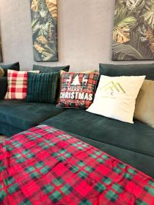 a green couch with plaid pillows on it at VOK Luxury Home I Tropical Living in Arad