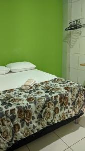 a bed with a floral comforter on top of it at Apartamento aconchegante in Marabá