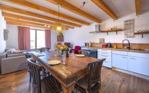 a kitchen and dining room with a wooden table and chairs at Wendelstein Lodge in Fischbachau