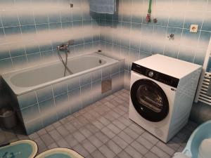 y baño con lavadora y bañera. en Apartmani Srebrenik, en Srebrenik