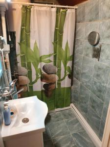 a bathroom with a shower curtain and a sink at Pure nature lovely view house in Zaklopača