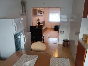 Una cocina y una sala de estar con refrigerador y una mesa. en Apartmani Srebrenik, en Srebrenik