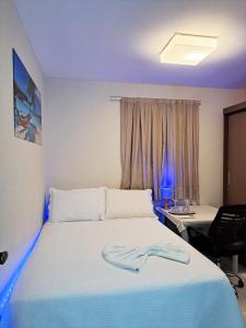 a bedroom with a bed and a desk and a window at Suíte INDIVIDUAL com Ar condicionado em AP Compartilhado in João Pessoa