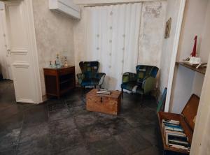 una camera con due sedie e un tavolo e una scrivania di P43 Sicilian Suites a Ragusa