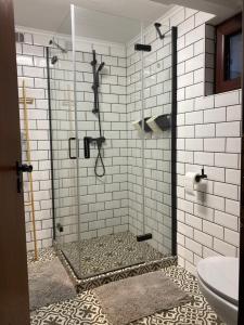 a shower in a bathroom with white tiles at Kućice za odmor Šalatin jarek - Free tickets to local attractions in Ðurđevac +40 photos