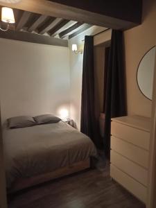 a bedroom with a bed and a dresser with a mirror at Le Bourguignon - Proche centre ville et Tram in Dijon +6 photos