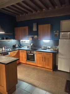 a kitchen with wooden cabinets and a white refrigerator at Le Bourguignon - Proche centre ville et Tram in Dijon