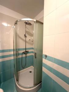 una ducha con puerta de cristal en un baño en Ergi’s Host Apartment, en Tirana
