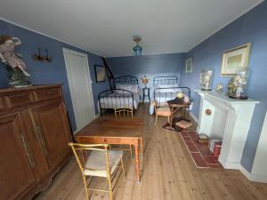 a room with two beds and a table and chairs at La Jeannette in Vains