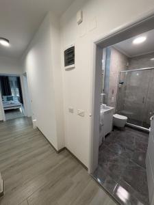 a bathroom with a shower and a toilet and a sink at Siena Lux Apartment in Gevgelija +34 photos